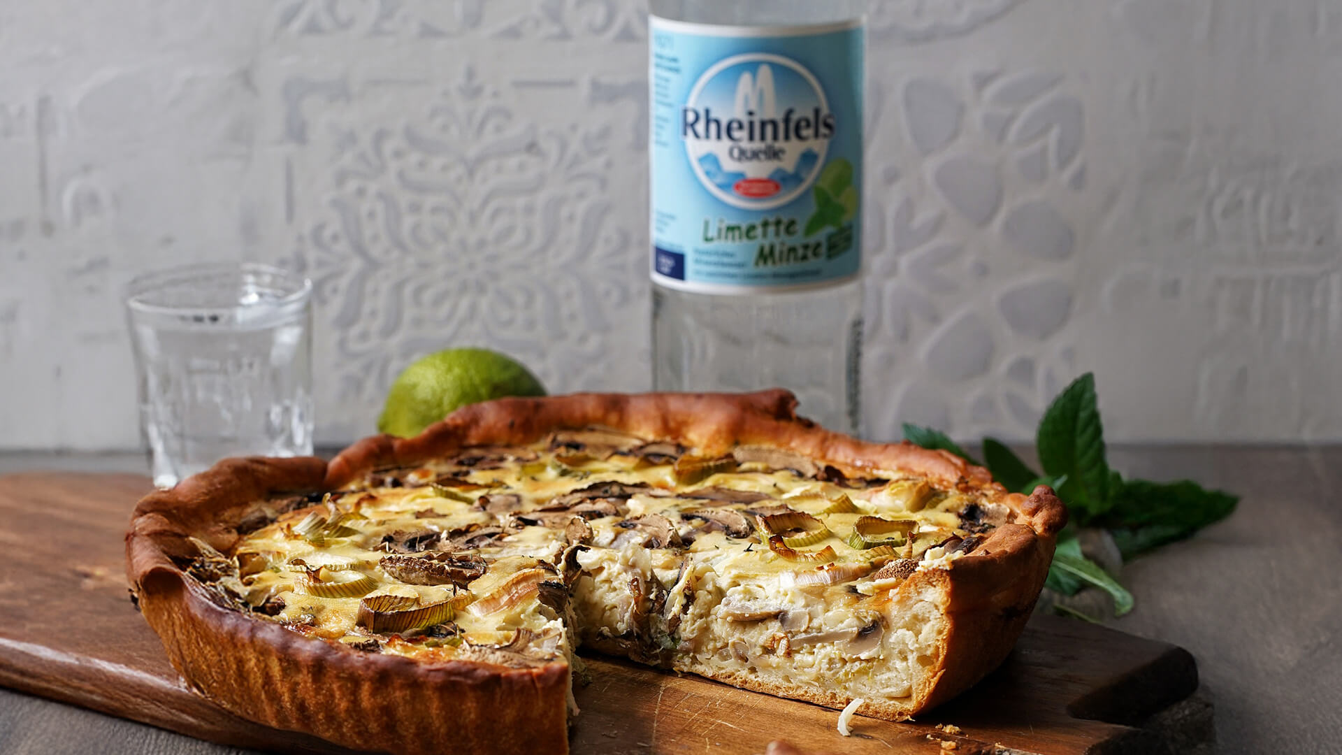 Champignon Lauch Quiche mit einer Rheinfels Quelle Limette-Minze Flasche