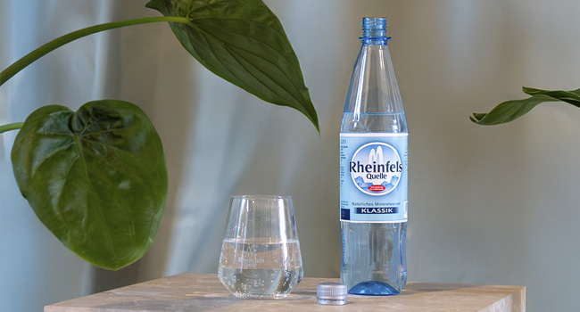 Flasche Rheinfels Klassik, daneben ein gefülltes Wasserglas