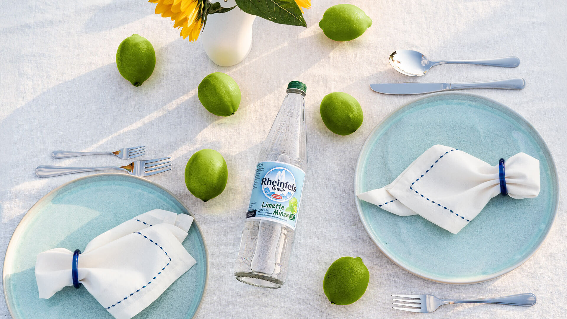 Rheinfels Quelle Limette-Minze Flasche auf gedecktem Tisch.